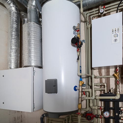 Heating and water supply system in a new residential building. Pipe wiring. The room is under construction with a rough finish, plastered walls, concrete floor and ceiling.